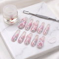 Sakura Kiss press-on nails with translucent pink, sculpted blossom flowers, pearls and silver foil